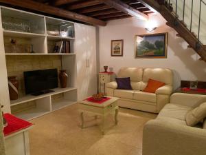 ein Wohnzimmer mit einem Sofa und einem TV in der Unterkunft San Domenico Suite in Martano
