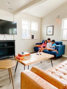 two children are sitting on a couch in a living room at Boardwalk Cottages in Long Beach