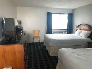 una camera d'albergo con due letti e una televisione di Motel 6 Missoula, Mt - Wye - Travel Plaza a Missoula