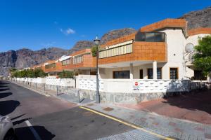 a building on a street with mountains in the background at GIGANTES Oasis Deluxe by Sunkeyrents in Santiago del Teide