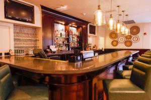 a bar with a large wooden table and chairs at Casa De Palmas, Trademark Collection by Wyndham in McAllen