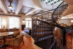 a spiral staircase in a restaurant with tables and chairs at Casa De Palmas, Trademark Collection by Wyndham in McAllen