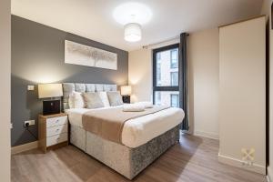 a bedroom with a large bed and a window at Arcadian City Centre Apartment in Birmingham