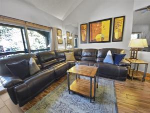 Una sala de estar con un sofá de cuero y una mesa. en Powder Ridge 209 condo, en Breckenridge