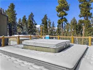 un jacuzzi en una terraza en la nieve en Powder Ridge 209 condo, en Breckenridge