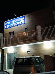 una señal en el lateral de un edificio con coche en HOTEL CIDADE EXPRESS 24H en Teresina
