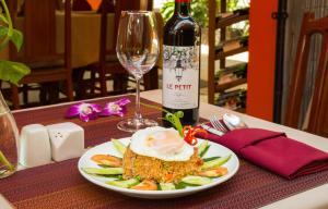 a plate of food and a bottle of wine on a table at Saline Residence in Siem Reap