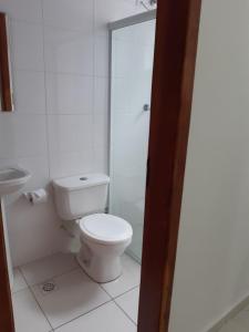 La salle de bains blanche est pourvue d'une douche et de toilettes. dans l'établissement Apartamento 2 dorm na Guilhermina com tudo novo, Localização Incrível! Internet 200 MB, à Praia Grande