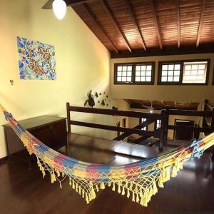 a large hammock in a living room with a table at Casa da Mayner in Trindade