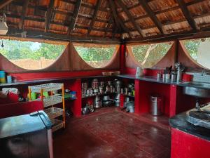 a red kitchen with a counter and some windows at Paradise Vana Vilasa Homestay with Swimming pool in Auroville
