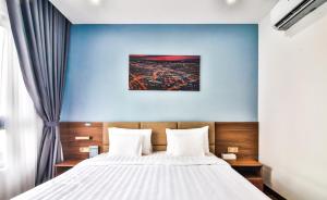 um quarto com uma cama grande e uma parede azul em Grand Lee Hotel em Ho Chi Minh