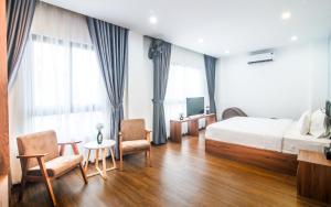 een hotelkamer met een bed en twee stoelen bij Grand Lee Hotel in Ho Chi Minh-stad