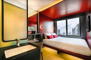 a bedroom with a bed and a sink and a mirror at The Upper House, Batu Kawan in Batu Kawan