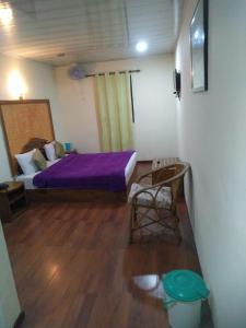 1 dormitorio con 1 cama y 1 silla en Red Star Holidays, en Munnar