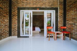 a room with two chairs and a table and a brick wall at Asri Village in Uluwatu