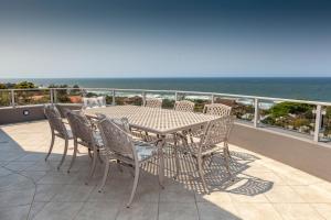 a table and chairs on a balcony with the ocean at Danara Place in Zinkwazi Beach