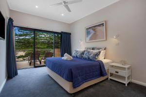 
a bedroom with a bed, a desk, and a window at Sea Foam Villas in Port Campbell
