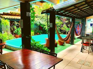 a patio with a table and hammocks and a pool at Villas Boas in Arraial do Cabo