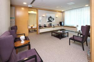 una sala de estar con muebles de color púrpura y una sala de espera. en Masel Hotel en Adana