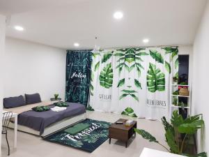 Zimmer mit einem Bett und einem Vorhang mit Pflanzen in der Unterkunft SHAHALAM ALLBESS@TREFOIL in Setia Alam