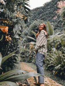 a woman talking on a cell phone while standing in a field at Our Jungle House - SHA Certified in Khao Sok National Park