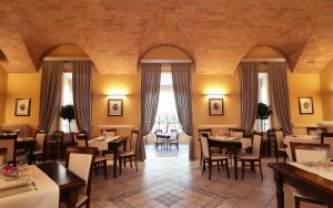 una sala da pranzo con tavoli, sedie e finestre di Albergo Chiusarelli a Siena