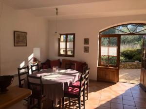 een eetkamer met een tafel en stoelen en een open deur bij Le Mas de Fanny in Faucon
