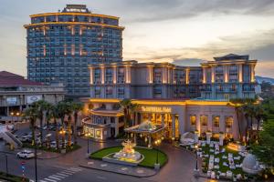 un hôtel avec un grand bâtiment en arrière-plan dans l'établissement The IMPERIAL Vung Tau Hotel, à Vung Tau