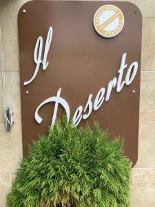 a sign for a store with a plant in front of it at Locanda il Deserto in Livorno