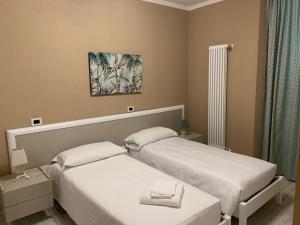um quarto com duas camas e um quadro na parede em Locanda il Deserto em Livorno