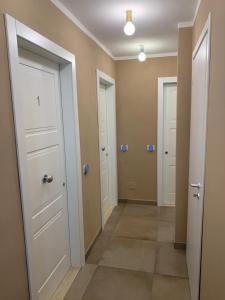 a hallway with three doors and a tile floor at Locanda il Deserto in Livorno