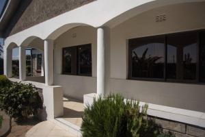 a house with columns and windows and plants at Reens Vacation Rentals in Nakuru