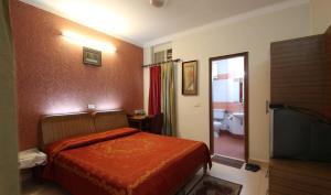 une chambre d'hôtel avec un lit et une télévision dans l'établissement Nu Delhi Homestay, à New Delhi