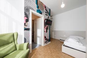 a living room with a green couch and a bed at Stay COOPER l Capitol Rooms in Bolzano