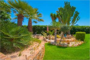 een tuin met palmbomen en een stenen muur bij Home SEA&DREAMS NiceView in Calpe