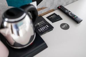 a black and white coffee pot next to a remote control at Stay COOPER l Capitol Rooms in Bolzano