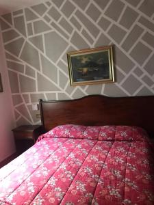 Un dormitorio con una cama roja y una pintura en la pared en Hotel Chopin, en Milán
