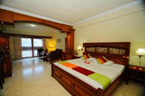 a bedroom with a large bed and a dining room at Melasti Beach Resort & Spa Legian in Legian