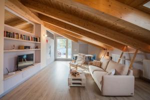 ein Wohnzimmer mit einem weißen Sofa und Holzdecken in der Unterkunft Loft 29 mansardato con ampio terrazzo in Bussoleno