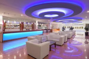 - un hall avec des chaises blanches et un plafond bleu dans l'établissement Oceanis Beach Hotel, à Ixia