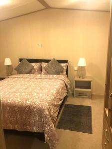 um quarto com uma cama e duas mesas de cabeceira em Seaside Cove Static Holiday Home With Private Hot Tub em Mablethorpe