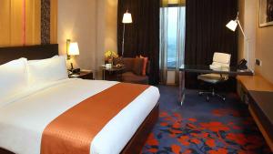 a hotel room with a large bed and a desk at Holiday Inn New Delhi Mayur Vihar Noida, an IHG Hotel in New Delhi