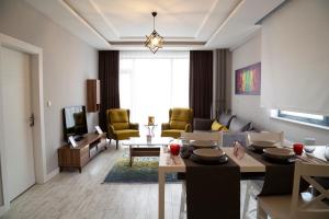 a living room with a couch and a table at Hatton Suites Hotel Esenboga in Ankara