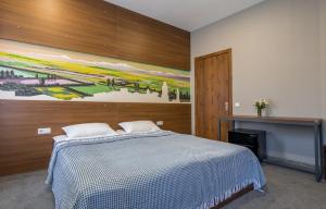 a bedroom with a bed and a painting on the wall at Hotel History • სასტუმრო ისტორია in Sighnaghi
