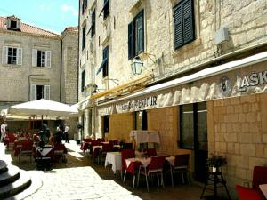 a restaurant with tables and chairs outside of a building at Apartments Adriana Flora in Dubrovnik