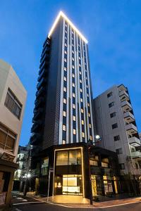 un edificio alto con luci sopra di HOTEL ASYL TOKYO KAMATA a Tokyo