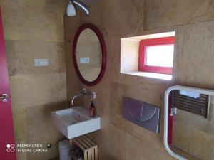 a bathroom with a sink and a mirror and a window at La Casita de León in León