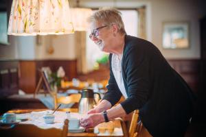 an older woman sitting at a table eating food at Landgasthof Keller in Überlingen