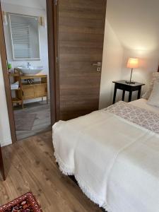 a bedroom with a bed and a bathroom with a sink at Helga Vendégház in Budaörs