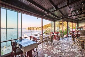 een restaurant met tafels en stoelen en uitzicht op het water bij Hayalbaz in Izmir